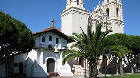 Старая церковь миссии Долорес рядом с пышной базиликой